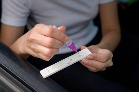 A woman do a self-collection test for a COVID-19 test, health and safety