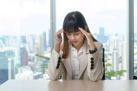 A young business Woman stressed and tired in modern officeの写真素材