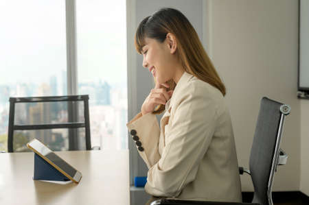 A young business Woman looking at screen while business meeting through video conferencing application in modern officeの写真素材