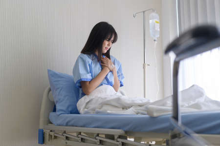 A despondent Asian woman patient. Following the doctor's declaration that the cancer was nearing the end of its course.の写真素材