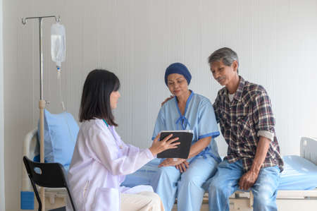 Cancer patient woman wearing head scarf after chemotherapy consulting and visiting doctor in hospital..の写真素材