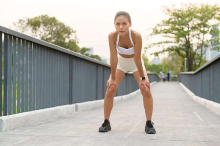 A young fitness woman in sportswear tired and exhausted in city park, Healthy and Lifestyles.の写真素材