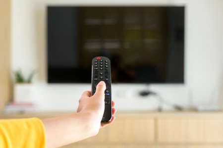 Close up of hand holding  tv remote controllerの写真素材