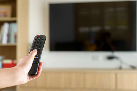 Close up of hand holding  tv remote controllerの写真素材