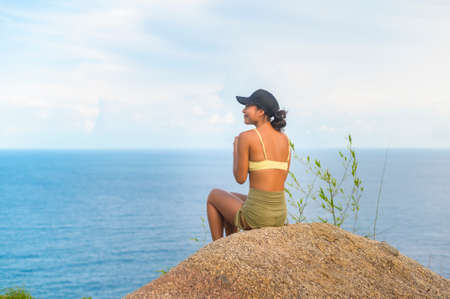 A Beautiful asian woman in sportswear doing yoga on seaside mountain peak after trekking, Travel and meditation concept.の写真素材