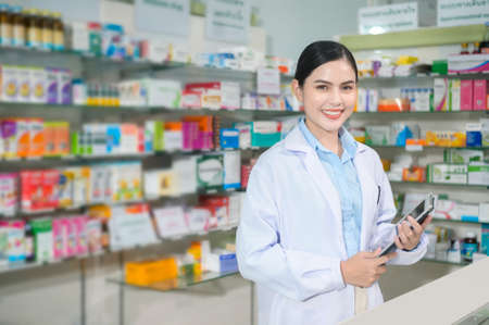 A Portrait of female pharmacist using tablet in a modern pharmacy drugstore.の写真素材