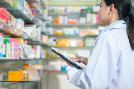 A Portrait of female pharmacist using tablet in a modern pharmacy drugstore.の写真素材