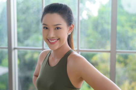 Portrait of fit young woman wearing sportswear at home, sport and healthy lifestyle concept.