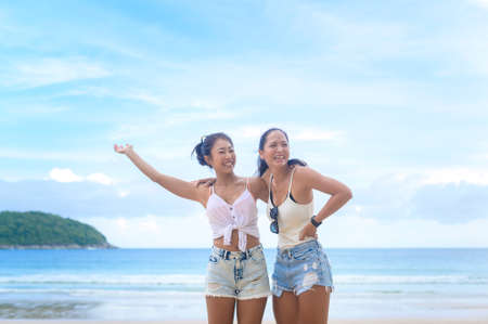 Two attractive women friends enjoying and relaxing on the beach,  Summer, vacation, holidays, Lifestyles concept.の写真素材