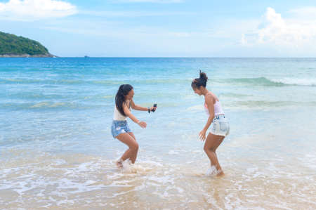 Two attractive women friends enjoying and relaxing on the beach,  Summer, vacation, holidays, Lifestyles concept.の写真素材