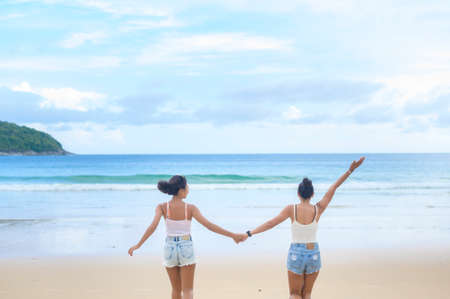 Two attractive women friends enjoying and relaxing on the beach,  Summer, vacation, holidays, Lifestyles concept.の写真素材