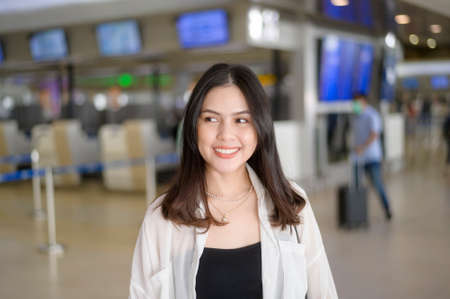 A Young female traveler carrying suitcases at the International airport, travel, holidays and journey concept.の写真素材