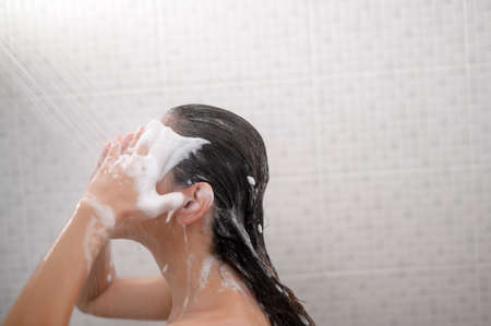 A Happy beautiful woman is taking a showerの写真素材