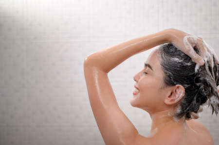 A Happy beautiful woman is taking a showerの写真素材