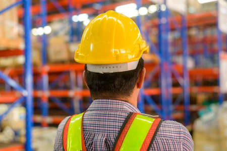 A Portrait of senior asian male worker wearing helmet in modern warehouse storage of retail shopの写真素材