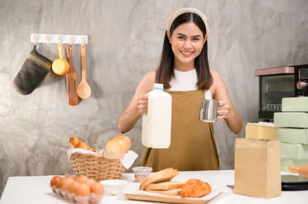 A Young beautiful woman is baking in her kitchen , bakery and coffee shop businessの写真素材
