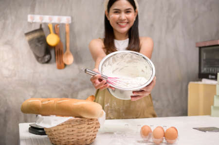 A Young beautiful woman is baking in her kitchen , bakery and coffee shop businessの写真素材
