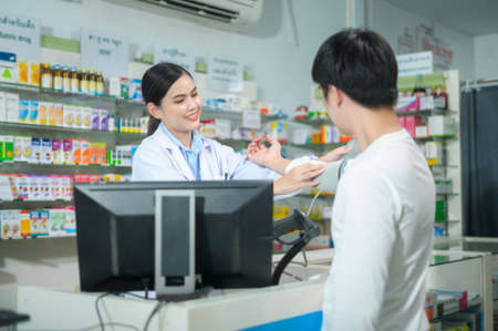 A Female pharmacist counseling customer about drugs usage in a modern pharmacy drugstore.の写真素材