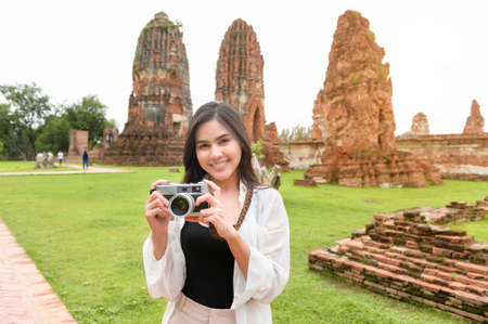 young beautiful woman traveling and taking photo at thai historical Park, Holidays and cultural tourism concept.の写真素材