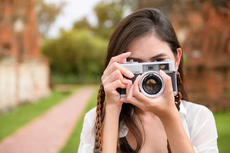 young beautiful woman traveling and taking photo at thai historical Park, Holidays and cultural tourism concept.の写真素材