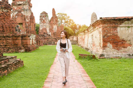 young beautiful woman traveling and taking photo at thai historical Park, Holidays and cultural tourism concept.の写真素材
