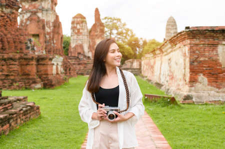 young beautiful woman traveling and taking photo at thai historical Park, Holidays and cultural tourism concept.の写真素材