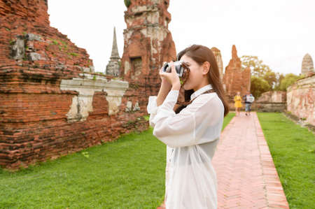 young beautiful woman traveling and taking photo at thai historical Park, Holidays and cultural tourism concept.の写真素材
