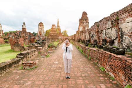young beautiful woman traveling and taking photo at thai historical Park, Holidays and cultural tourism concept.の写真素材