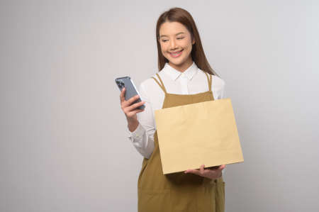 A Portrait of young asian woman wearing apron over white background studio, cooking and entrepreneur...