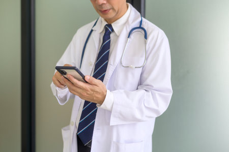 Portrait of confident smiling doctor wearing white coat in hospitalの写真素材