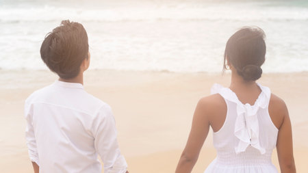 A Happy young couple wearing white dress on the beach on holidays, travel, romantic, wedding conceptの写真素材