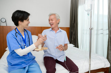 An Asian nurse giving an elderly medicine at  senior healthcare center.の写真素材