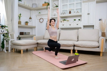 An Asian young woman is workout on fitness mat , exercise at home , healthy lifestyle conceptの写真素材