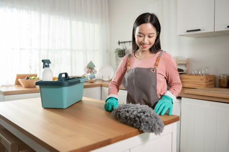 Happy Asian young woman sweeping sofa and furniture to cleaning house, healthy lifestyle conceptの写真素材
