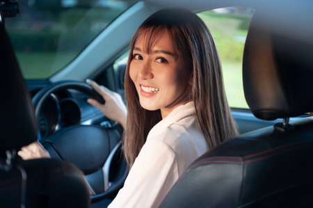 A Young asian beautiful woman driving a car with fastened seatbelt