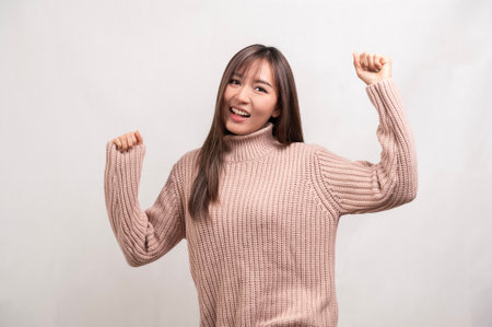 A Portrait of young asian woman wearing sweater over white backgroundの写真素材
