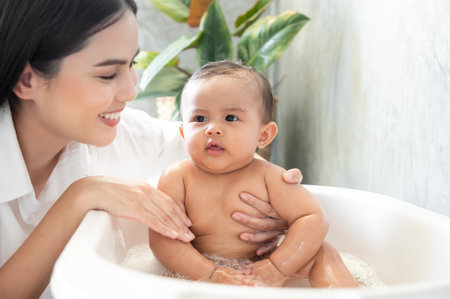 Adorable baby girl taking a bath with mother, family, child, childhood and parenthood conceptの写真素材