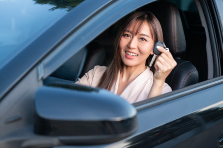 A Young asian beautiful woman driving a car with fastened seatbeltの写真素材