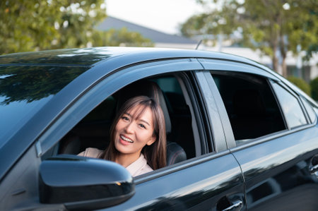 A Young asian beautiful woman driving a car with fastened seatbeltの写真素材