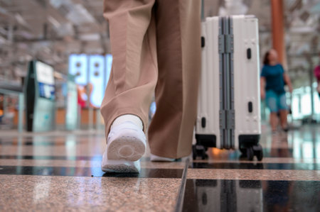 Close-up woman foot walking with suitcase , check in at International airport , vacation travel and transportation conceptの写真素材