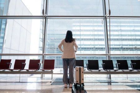 A young beautiful woman walking with suitcase , check in at International airport , vacation travel and transportation conceptの写真素材