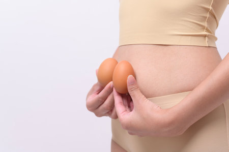 Close up woman holding eggs on belly , prepare reproductive fertility , Ovulation stimulation , matherinty conceptの写真素材