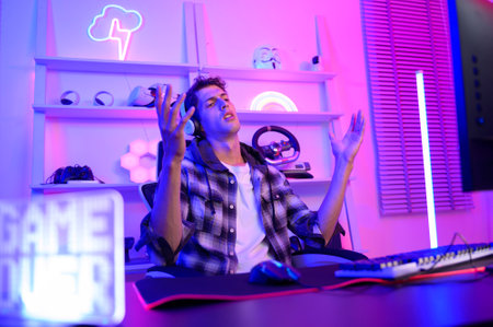 Young Caucasian man Pro Gamer have live streaming  and chatting  with his  fans at homeの写真素材