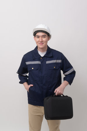 Portrait of male engineer wearing a protective helmet over white background studio.の写真素材