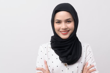 Portrait of beautiful muslim woman with hijab over white background studio.