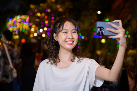 Beautiful young Asian tourist woman on vacation sightseeing and exploring at Khao San road at night in Bangkok city, Thailand, Holidays and traveling conceptの写真素材