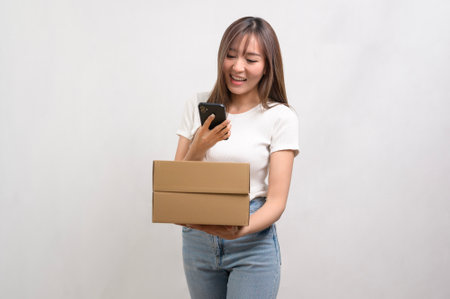 A Young asian woman holding paper box and cardbord box over white background, Save earth and delivery conceptの写真素材