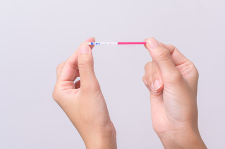 Close up woman using Ovalation (LH) test  or (HCG Pregnancy test) on white backgroundの写真素材