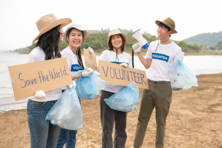 Volunteers from the Asian youth community using rubbish bags cleaning  up nature parの写真素材