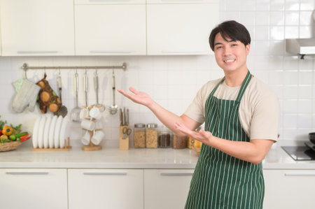 portrait of smart young Asian man smiling  in kitchen at homeの写真素材